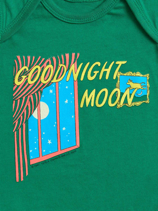 A close-up of a green baby bodysuit featuring a colorful graphic print with the words 'GOODNIGHT MOON' in yellow, a window with red striped curtains, and a full moon scene.