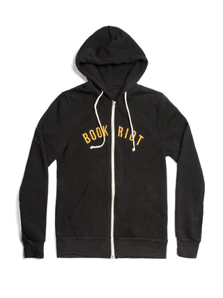 A black zip-up hoodie with white drawstrings and a white front zipper, featuring the words 'BOOK RIOT' printed in yellow across the chest, displayed on a clean white background.