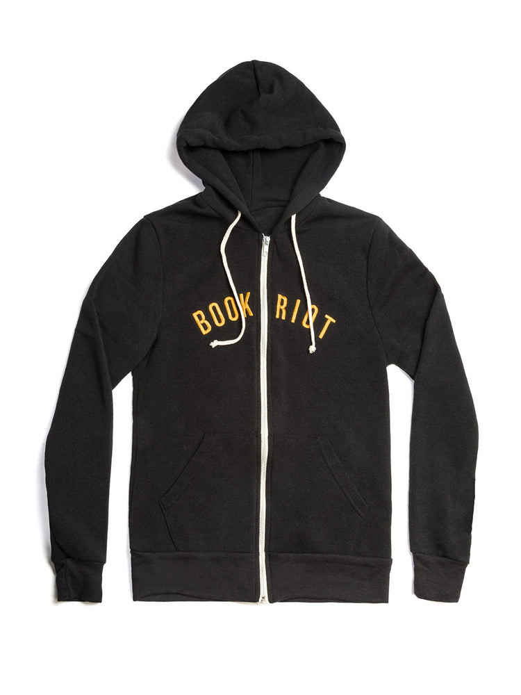 A black zip-up hoodie with white drawstrings and a white front zipper, featuring the words 'BOOK RIOT' printed in yellow across the chest, displayed on a clean white background.