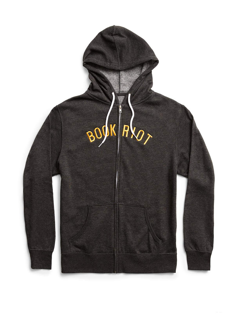 A dark heather gray zip-up hoodie with 'BOOK RIOT' printed in yellow across the chest, featuring white drawstrings and a front pocket, shown against a plain white background.