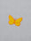 A yellow embroidered butterfly motif outlined in orange on a light gray fabric background.